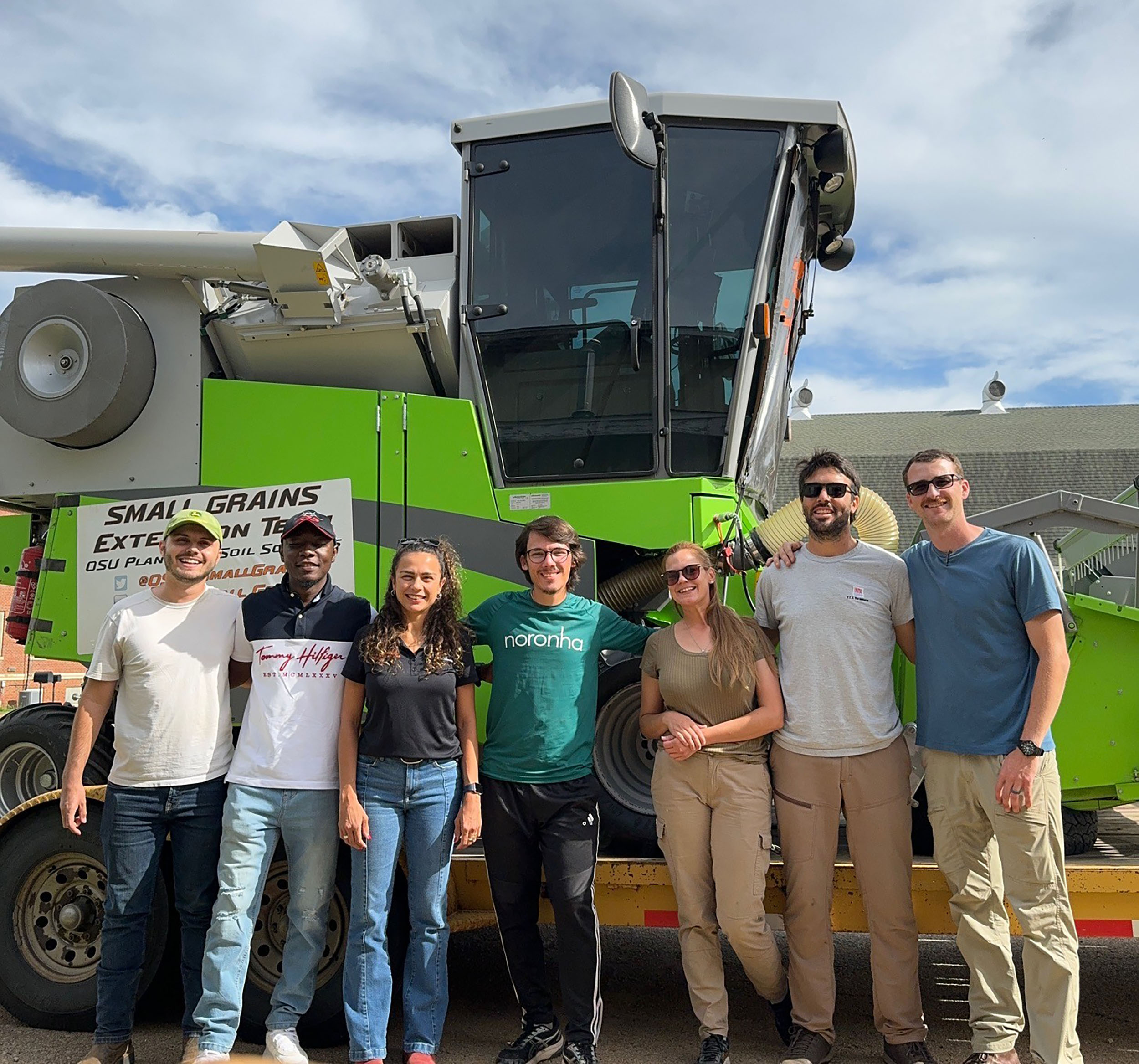 The 2024 OSU Small Grain Team stands next to each other in front of farm equipment.
